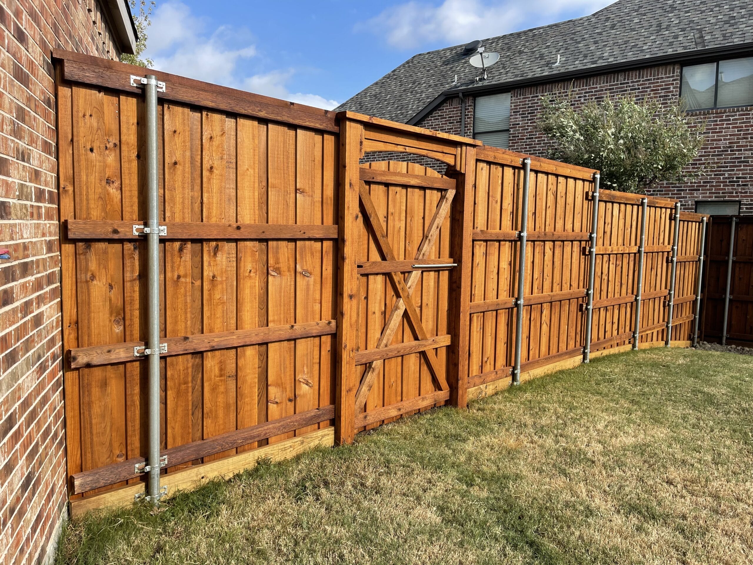 A beautiful wooden fence surrounds a Sherman, TX, home, showcasing popular fencing options.