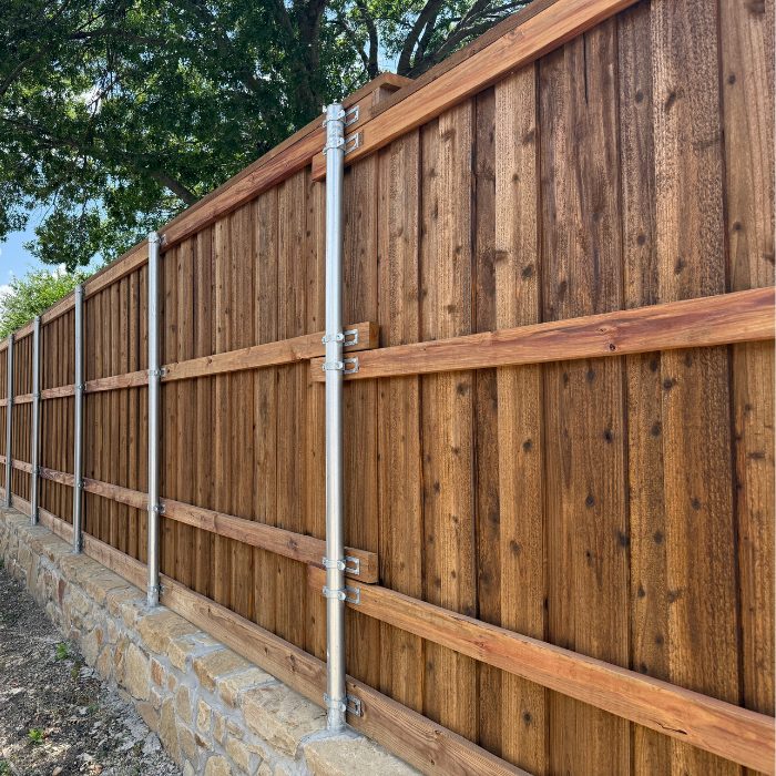 Project Photo (6) Stained cedar privacy fence with steel posts and cap on stone retaining wall