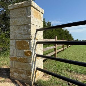 Pipe fence with a stone column